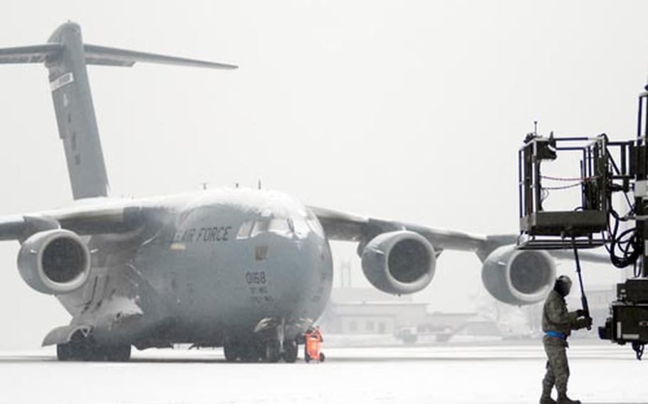 Senior Airman Keith Allen, a crew chief with the 721st Aircraft Maintenance Squadron, stows a piece of equipment Monday on Ramstein&#39;s snow-covered flight line.