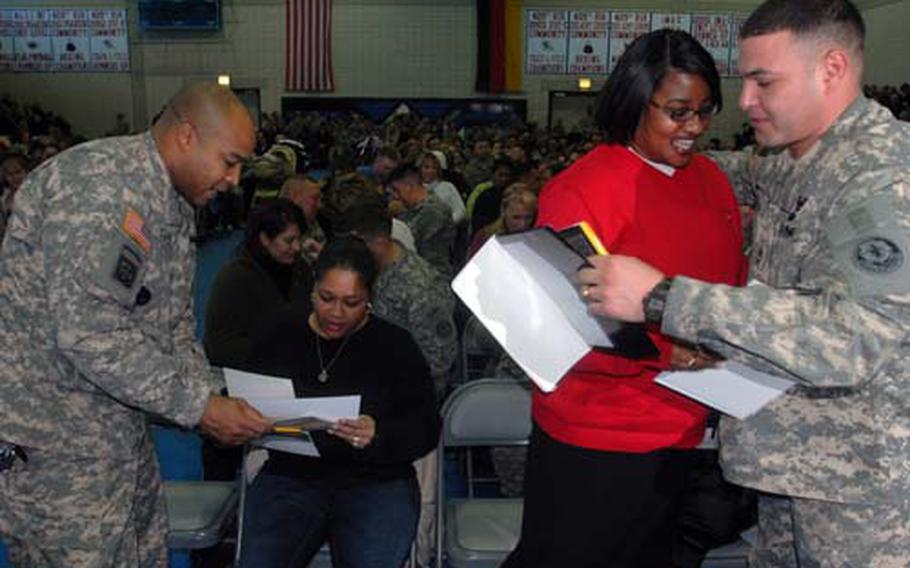 Command Sgt. Maj. Everett Clark, left, presents a Freedom Team certificate to his wife, Valecia, while Tiesha Saldana, right center, receives a certificate from her husband, Sgt. 1st Class Armando Saldana, at Vilseck’s Memorial Fitness Center on Thursday.
