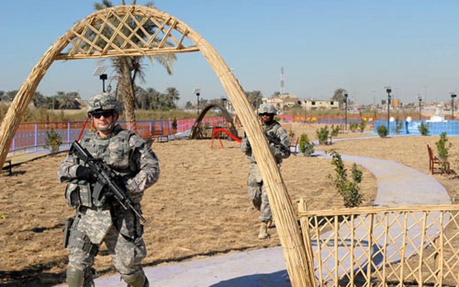 Capt. Philip O’Brien (front) and Sgt. Curtis Calhoun walk under an arch Wednesday at Wishbone Park in Baghdad’s Sadr City district. The peninsula that the parks sits on was once overgrown with weeds, allowing hidden enemy fighters to spy on a nearby joint security station. By building the park, U.S. forces took away the spot from insurgents, a tactic dubbed “non-lethal terrain denial.”