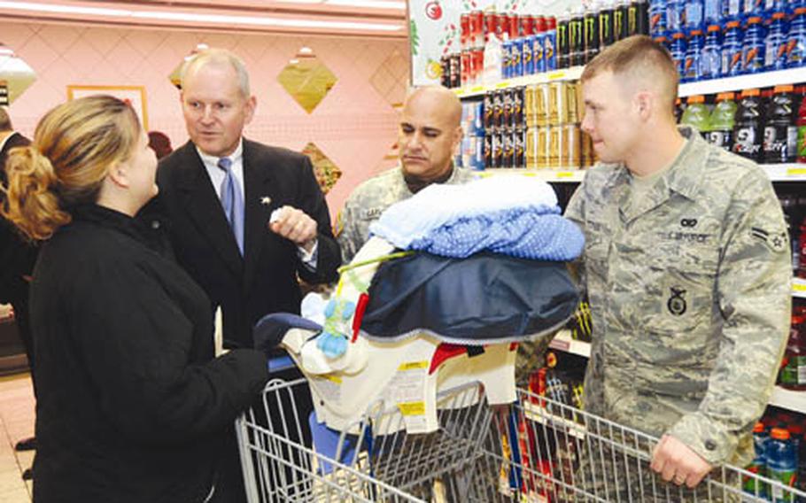 Sakowitz, second from left, and Command Sgt. Maj. Victor Garcia talk to Airman 1st Class Joshua Titus, right, and his wife, Brittany, as they shop in Kaiserslautern, Germany’s Vogelweh commissary with their son, Dakota.