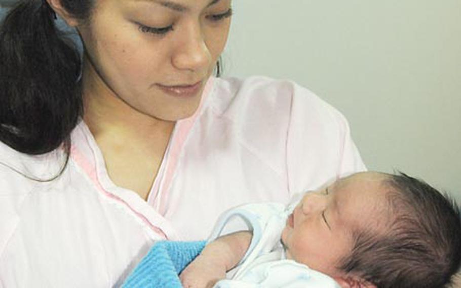 Hotaru Ferschke cradles her newborn son, Michael H. Ferschke III, at a Japanese clinic near Kadena Air Base on Tuesday. Michael, born Jan. 9, was named for his father, Marine Sgt. Michael H. Ferschke Jr., who was killed in Iraq in August.