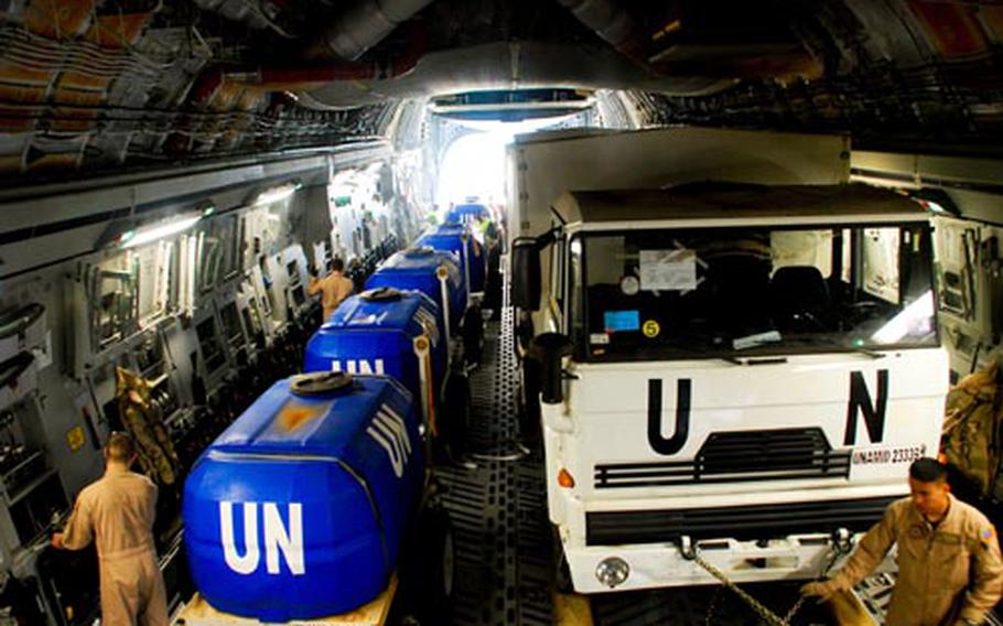At Kigali International Airport, Rwanda, load masters from Travis Air Force Base, Calif., secure the DAF vehicle and water holding tanks onboard the C-17. This is the first load of five airlifts to the United Nations mission in Darfur.