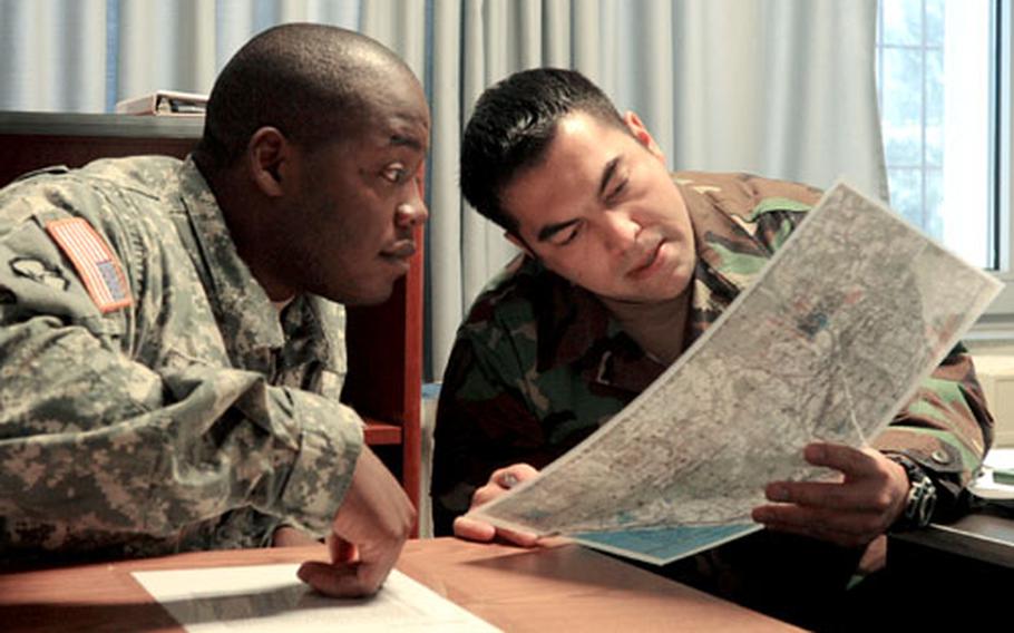 Tech. Sgt. Nicholas Picoc, right, the chief joint terminal attack controller instructor at the U.S. Air Forces in Europe&#39;s Air Ground Operations School at the Warrior Preparation Center in Einsiedlerhof, Germany, looks over a map Wednesday with Sgt. 1st Class Virgil Allen, of Headquarters and Headquarters Company, 1st Battalion, 508th Parachute Infantry Regiment, 82nd Airborne Division. Allen is going through joint fires observer training. Members of the 82nd are training at the center as they prepare for their deployment to Afghanistan.