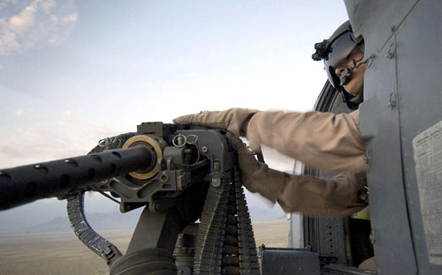 Senior Airman Ryan Ballinger, an aerial gunner with the Kadena-based 33rd Expeditionary Rescue Squadron, checks out the .50-caliber machine gun on an HH-60G Pave Hawk Aug. 2 during a training flight at Bagram Air Base in Afghanistan. Ballinger was among airmen in the squadron’s first flight to Afghanistan that provided help for combat search-and-rescue missions.