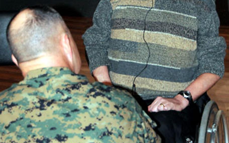 Col. Frank H. Simonds Jr., left, commander of Headquarters and Service Battalion, Marine Corps Base Camp Butler, talks with Bernie Inman on Tuesday at the Camp Foster Theater. Inman had just spoken to Marines about workplace safety and the workplace accident that left him in a wheelchair.