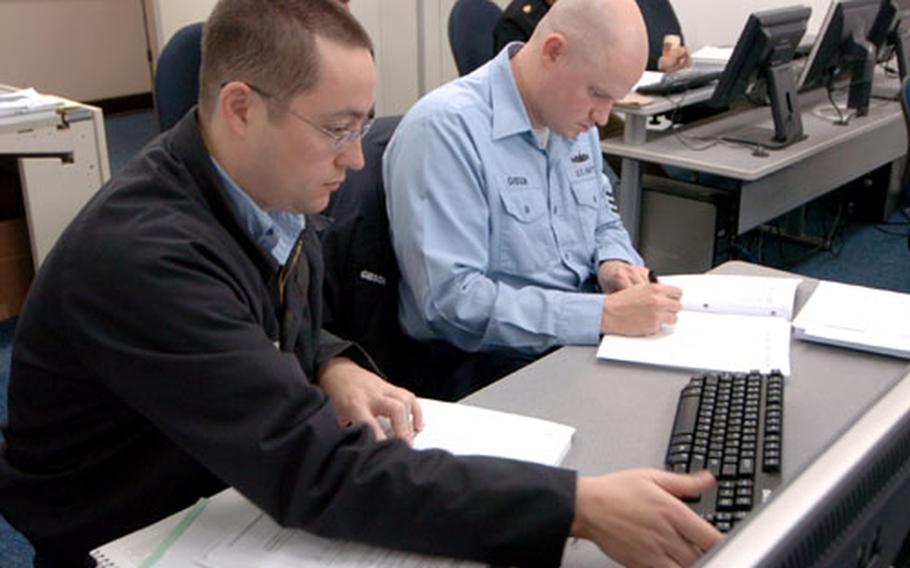 First class petty officers Corey Gronli, left, from Defense Distribution Yokosuka Japan, and Carey Gibson from Naval Air Facility Atsugi, work on getting their Volunteer Income Tax Assistance certifications Thursday in a classroom on Yokosuka Naval Base.