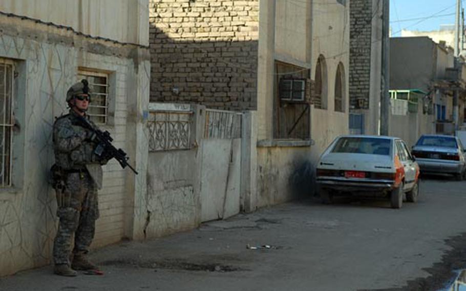 A soldier with 1st Combined Arms Battalion, 18th Infantry Regiment watches over a street corner Tuesday during a patrol through Baghdad’s Shula district. American combat units such as the 1/18 expect to play a smaller part in this year’s provincial elections than they did four years ago.
