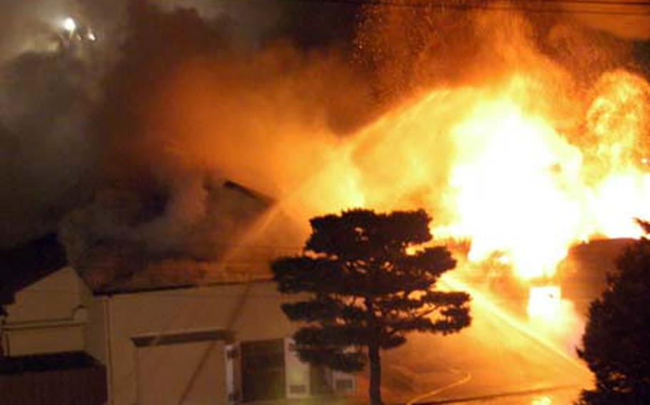 As firefighters battle the blaze, flames soar into the air after a portion of the roof collapsed on the DFAS Japan offices Tuesday night.