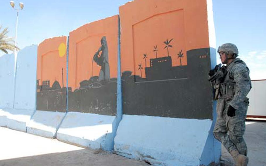 Sgt. Daniel Rodriguez, of 1st Battalion, 21st Infantry Regiment, 25th Infantry Division, stands watch at a mural at the newly opened Abu Ghraib government center. The painting depicts the Ali Baba fable, a symbol of justice in the Arabic world.