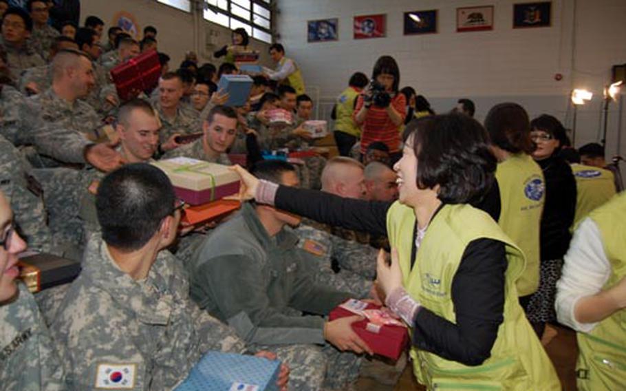 Grace Lee, of the International We Love U Foundation, hands out gift boxes to servicemembers Thursday at Collier Field House. The foundation donated 1,000 gift boxes to servicemembers at Yongsan as a show of appreciation for their work in South Korea.