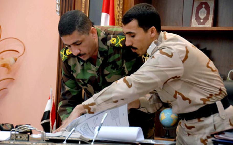 Gen. Ra&#39;id Shaker Jawdak, Wasit provincial director of police, left, and his aide, right, look over papers in Ra&#39;id&#39;s office less than a week after he was named head of the police force there. Ra&#39;id holds a key position in maintaining security in the province, which some Iraqi and U.S. officials say could be tested during the Jan. 31 provincial elections.
