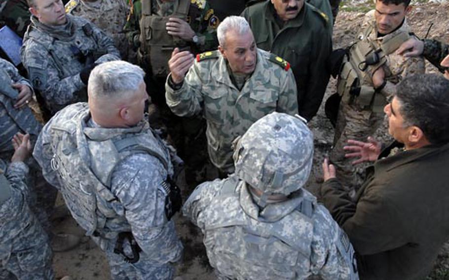 A Kurdish Peshmerga general, center, gestures during a discussion on where to put joint Kurdish-Arab election day checkpoints in northeastern Diyala province, an area claimed by both ethnic groups. U.S. Lt. Col. Mike Kasales, left, spent three weeks mediating negotiations between the groups. Below: An Iraqi flag, foreground, flies with Kurdish flags at a Kurdish Peshmerga checkpoint in northeastern Diyala province. Iraqis worry the area, disputed between Arabs and Kurds, could be a flashpoint for ethnic violence.