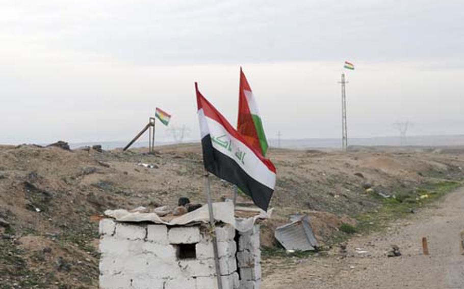 An Iraqi flag (foreground) flies with Kurdish flags at a Kurdish Peshmerga checkpoint in northeastern Diyala Province. Iraqis worry the area, disputed between Arabs and Kurds, could be a flashpoint for ethnic violence.