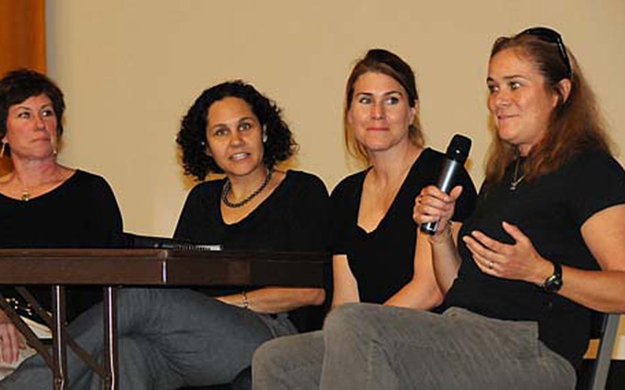 Lt. Cmdr. Valerie Riege, right, with the Pharmacy Department of U.S. Naval Hospital Okinawa, shares advice with an audience of more than 300 female Marines and sailors gathered at the Camp Foster Theater on Thursday for the daylong Sister to Sister Women’s Symposium.