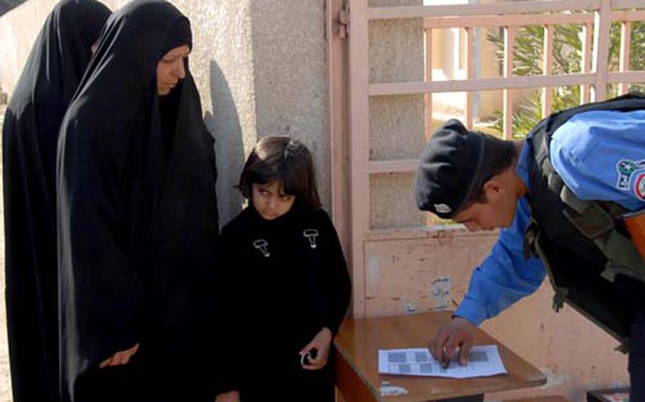 Two Iraqi women and a child wait to be admitted to a polling station in Kut. The women were turned away because their names weren't on the voting lists, a problem other voters had at this site throughout the day. An election worker said some people may have been improperly registered, but few other problems were reported in Wasit province during the election.