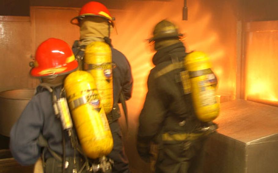 Students attack a galley fire Wednesday during a firefighting exercise at Yokosuka Naval Base, Japan. It was part of the Center for Naval Engineering’s Advanced Shipboard Firefighting course last week.