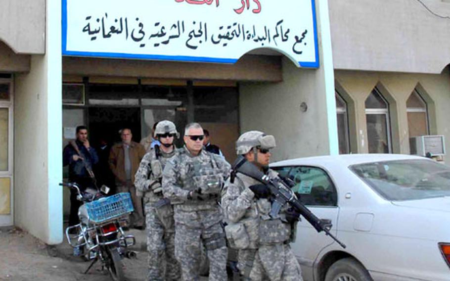 U.S. troops leave the Numaniyah courthouse in rural Wasit province after interviewing two judges. In the center is Art Oates, a contractor providing advice on law enforcement issues. The U.S. has started a task force in Wasit to evaluate courthouse security, teach Iraqi police investigators to get the information judges need to issue arrest warrants, and catalogue detainees being held in Iraqi jails.