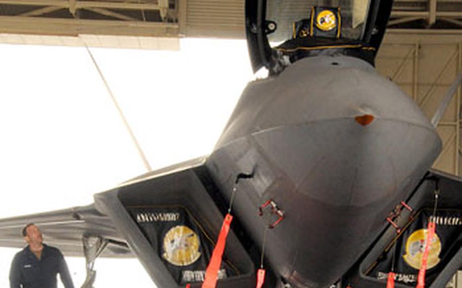 A crew chief walks around an F-22 Raptor at a squad bay on the flightline at Kadena Air Base on Thursday. The 27th Fighter Squadron, based at Langley Air Force Base in Virginia, brought 12 Raptors to Kadena for training.