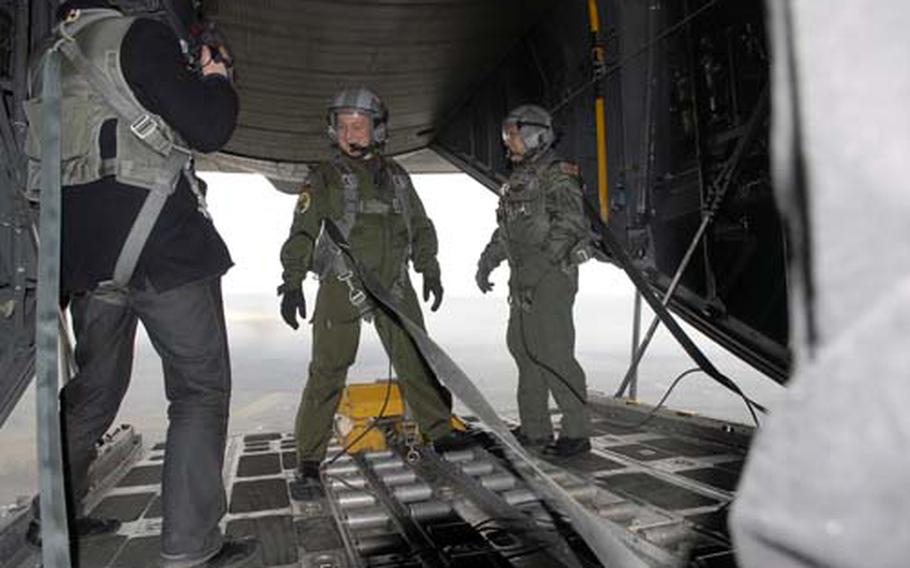 Tech. Sgt. Marty Landry, a loadmaster with the 37th Airlift Squadron at Ramstein Air Base, Germany, stands with a U.S.-trained Polish Air Force loadmaster on the open ramp of a C-130 during a low-level demonstration flight last week over Poland. The United States is planning to give Poland five C-130 aircraft later this year to help its central European ally enhance its airlift capabilities.