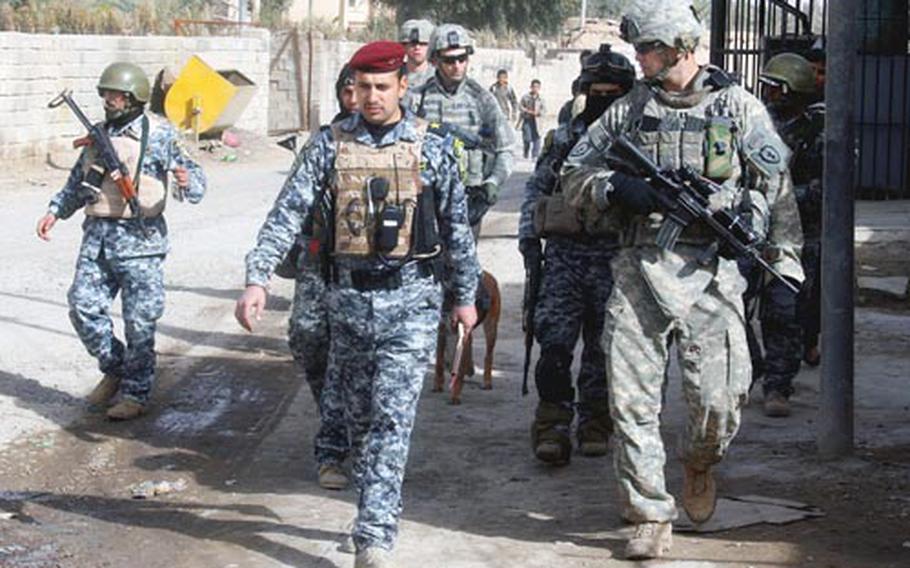 U.S. Army Capt. Brian Sweigart discusses the best plan of action for searching an Istaqlal Qada neighborhood with an Iraqi police officer during a combined patrol northeast of Baghdad, Iraq, Jan. 23, 2009, to secure the communitybefore the upcoming provincial elections. Sweigart commands the 25th Infantry Division's Headquarters Company, 1st Battalion, 27th Infantry Regiment, 2nd Stryker Brigade Combat Team.