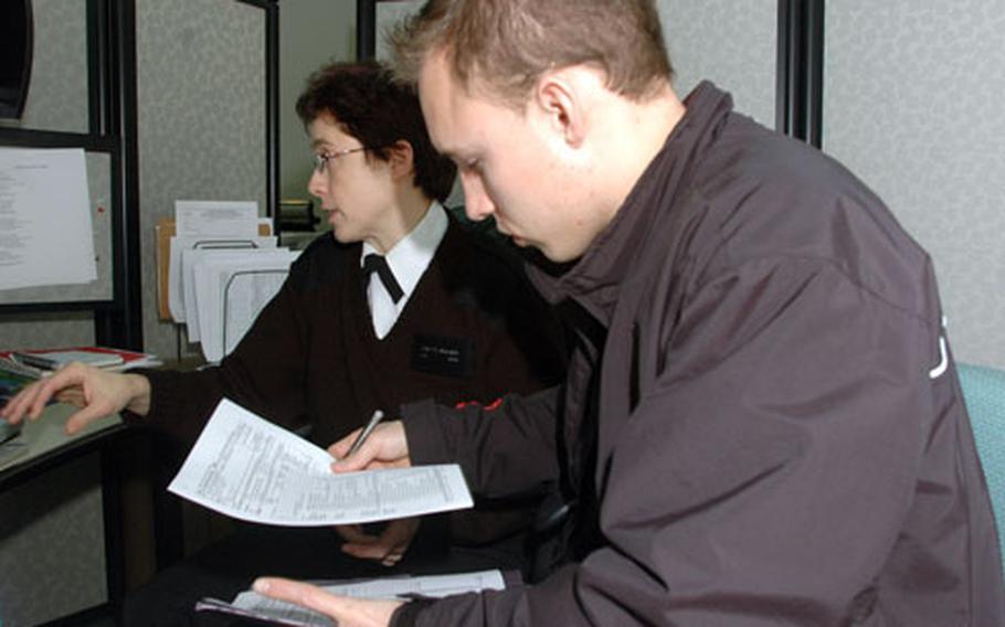 Petty Officer 2nd Class Alex Laskowski, 24, looks over his prepared tax form Wednesday. It was completed by Petty Officer 1st Class Lisette Walker, a volunteer and the organizer of the VITA Tax Center at Naval Support Activity Naples, Italy.