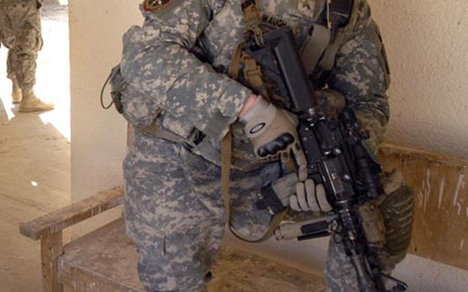 Sgt. Brandon Waugh, a soldier assigned to Company B, 1st Battalion, 2nd Infantry Regiment, watches as "Sons of Iraq" collect their final paychecks from the U.S. military on Tuesday near Iskandariyah, Iraq. Waugh is being considered for a battlefield promotion and an award for leading the successful medical evacuation of Sgt 1st Class Ammala Louangketh, Waugh's platoon sergeant. Louangketh was shot during a routine checkpoint stop Jan. 7th. Task Force 1-2 is deployed from Schweinfurt, Germany.