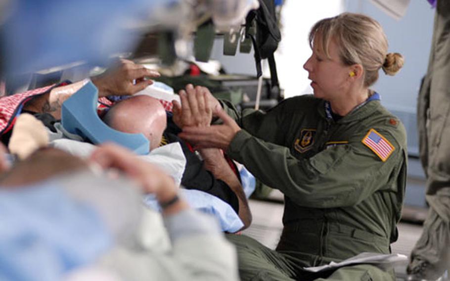 Air Force Maj. Elizabeth Barlow, a flight nurse with the 459th Aeromedical Evacuation Squadron, checks on Army Master Sgt. John Souza during a June 29 medical evacuation flight from Ramstein Air Base, Germany.