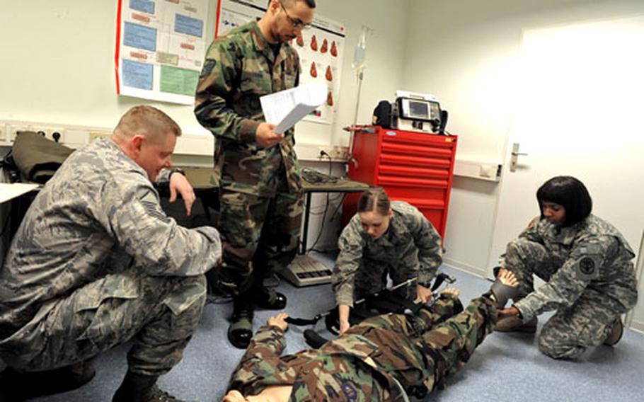 Senior Airman Brittany Arnold and Army Staff Sgt. Jaunan Polk, right, practice applying a Hare traction splint on a dummy during an emergency medical technician instructor course at Ramstein Air Base, Germany, on Wednesday. Instructing is Staff Sgt. Jamaal Frink, second from left, as Master Sgt. Joey Schlepper watches.