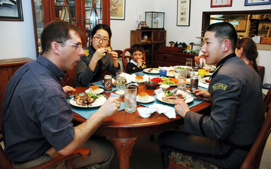 Air Force Lt. Col. Scott Maskery talks with Korean Military Academy cadets Jun Myung-ho, right, and Kim So-young, left, during dinner at the Maskerys’ home on Yongsan Garrison. About 190 graduating seniors visited Yongsan on Tuesday, meeting with U.S. military leaders and spending time with U.S servicemembers and their families.