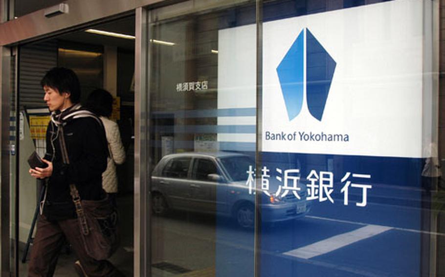 A customer exits the Bank of Yokohama in downtown Yokosuka on Wednesday. When the dollar rises quickly against the yen, off-base banks can provide a better exchange rate than the military bank rate.