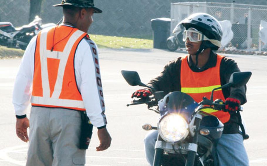 Paul Green, left, an instructor for the basic riders course, talks with a student on the course Wednesday at Kadena Air Base. The course is sponsored by the Marine Corps Bases Camp Butler Motorcycle Safety Office for all SOFA personnel.