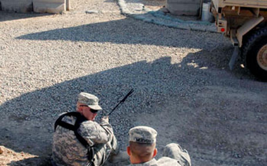 Staff Sgt. Jason McQuesten, left, and Sgt. Robert McEvoy fill some downtime at their joint security station by talking. Soldiers say there is little to do in their free time except watch television and movies, eat, and work out at the gym.