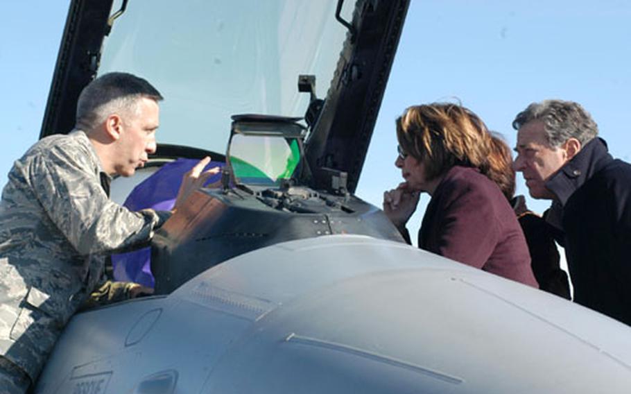 Col. Thomas Gould, commander of the 31st Operations Group at Aviano Air Base, Italy, explains some of the functions of an F-16 cockpit to Speaker of the House Nancy Pelosi, her husband, Paul, and Congresswoman Anna Eshoo (hidden), during a congressional delegation’s brief stop Saturday at Aviano.