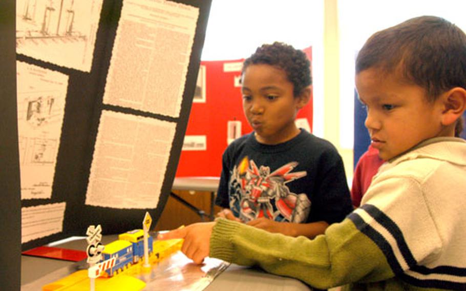 Kindergartners Shyzziah Rodgers, 6, left, and Uryan Brown, 5, check out the model railroad signal and train displayed in the temporary African American Inventors Museum at Kadena Elementary School on Okinawa. The railway signal was invented by A. B. Blackburn and patented in 1888. About 27 students in Kelley Sermons’ class were asked to re-create inventions developed by black Americans as part of Black History Month.