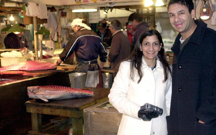 While tourists like Rahul and Reshma Aggarwal of Los Angeles are welcomed to smile for a keepsake during their Dec. 28 visit to Tsukiji Fish Market, complaints have prompted market officials to take action against unruly visitors who have reportedly been touching the tuna and disrupting morning tuna auctions with drunken behavior and flash photography.