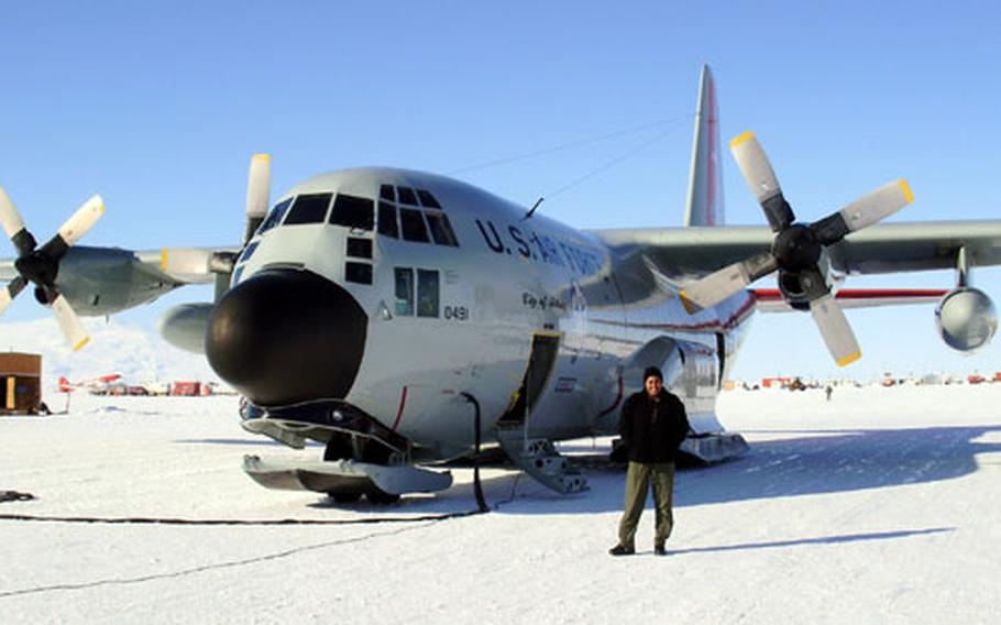 Air Force Tech Sgt. Leslie Green stands next to a LC-130 plane on skies at McMurdo Station in Antarctica. The plane helps transport patients to medical facilities at Christchurch, New Zealand.