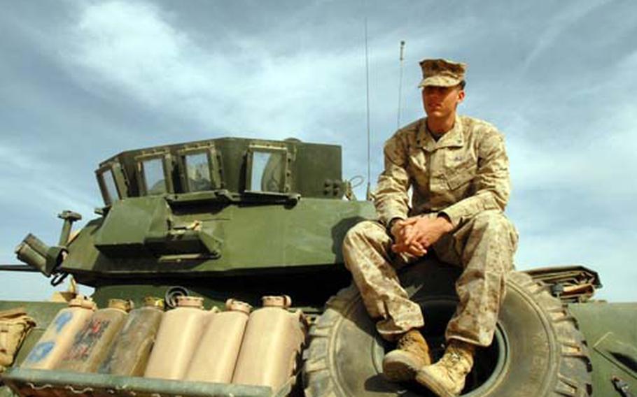 Cpl. Asa Akins sits on top of a Light Armored Vehicle at Al Asad Air Base, Iraq. Akins was one of 28 Marines who conducted a three-month presence patrol along in Anbar and Ninewa provinces. The group lived and worked out of four LAVs during their patrol, meeting with military convoys every three or four days to resupply themselves.