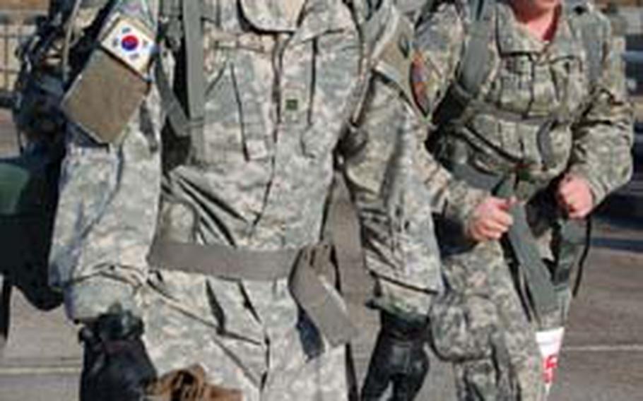Cpl. Kim Son-ho, Headquarters and Headquarters Company, U.S. Army Garrison Yongsan, squints through glasses that have steamed over during the frigid morning hours of the Bataan Memorial Death March qualifier Saturday at Camp Casey.