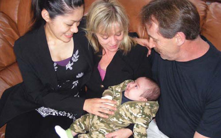 "Mikey" Ferschke's mom, Hotaru, and grandparents, Robin and Michael, share a special moment following a memorial service for Marine Sgt. Michael H. Ferschke Jr, Friday on Camp Schwab. Mikey and his mom will travel back to live with his grandparents in Maryville, Tenn., on Friday.
