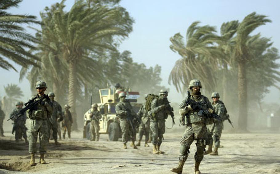Soldiers from 1st Platoon, Company A, Task Force 3-66 Armor and Iraqi troops wait in gusting winds before heading out on patrol Friday in Tahweela, Iraq.