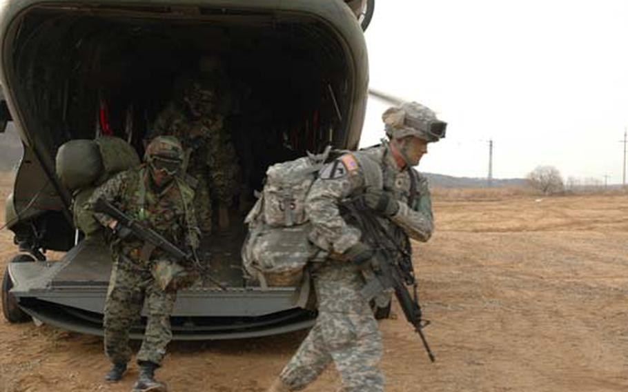South Korean and U.S. soldiers exit a Republic of Korea Army CH-47 helicopter Monday afternoon just outside of the Demilitarized Zone. Both Armies are stationed inside the DMZ, the border between North and South Korea. The U.S. and South Korea soldiers regularly practice evacuating from the area.