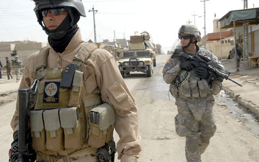 U.S. Army Sgt. John Thompson, background, patrols Mosul with his Iraqi counterparts during a joint operation Wednesday. The shooting of four American soldiers by two men in Iraqi police uniforms earlier this week highlights the trust issues between the two forces.