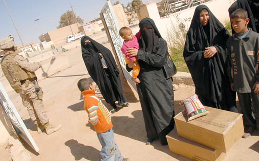 Women wait in line outside Rutbah’s city council building for food donated by the U.S. military. Rajwa Nasser Hibden, right, is a widow and lost her husband last fall when he went missing while traveling to the funeral for their 18-year-old son, an Iraqi policeman who was killed in a bomb blast. To her left is her 11-year-old son, Moustafa. Hibden relies on donated food and money that Moustafa and her other son, 12, earn from doing odd jobs.