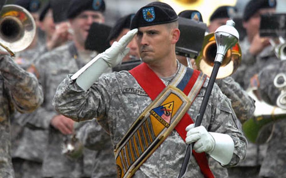 First Sgt. Adam Hefflefinger salutes as he leads the 1st Armored Division band past the reviewing stand at the conclusion of the division&#39;s change of command ceremony. Maj. Gen. Terry Wolff replaced Maj. Gen. Mark Hertling as the 1 AD commander on Tuesday.