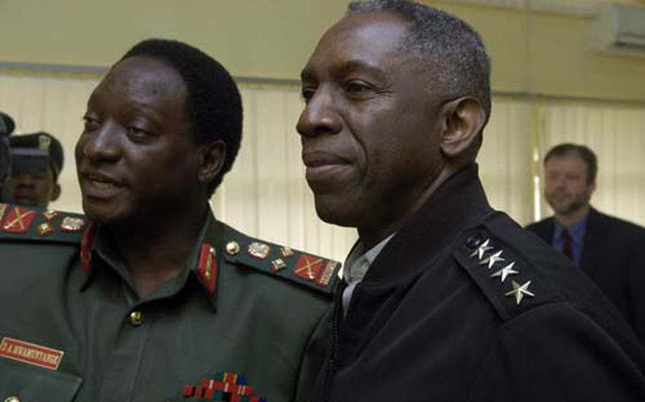 Tanzanian Gen. Davis Mwamunyange, left, and U.S. Army Gen. William “Kip” Ward, commander of U.S. Africa Command, look at some Tanzanian military photos before holding formal meetings Tuesday in Dar es Salaam, Tanzania. Ward, on a three-country tour of Africa, met with Tanzanian military officials to discuss training between the two countries.