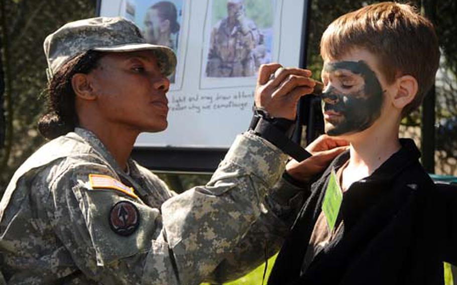 Staff Sgt. Clara Palacios applies camouflage makeup to Clayton Glauner at the Heidelberg Middle School&#39;s Kids Boot Camp on Tuesday.