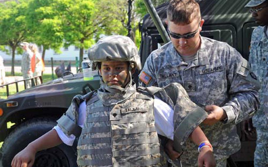 Spc. Chris Tallant puts protective gear on K.J. Parker.