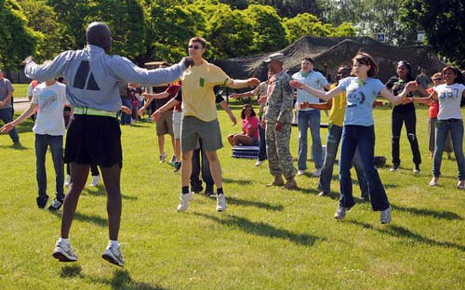 Staff Sgt. Jermaine Ellis leads a group of Heidelberg Middle School students through a set of jumping jacks.
