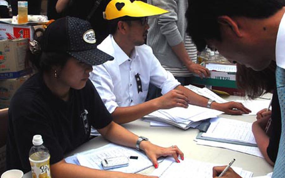 During Friday&#39;s funeral for former South Korean President Roh Moo-hyun, activists collect signatures on a petition calling for current President Lee Myung-bak to resign. Many believe Lee allowed a corruption investigation against Roh to become unfairly harsh, pushing the former president to commit suicide May 23.