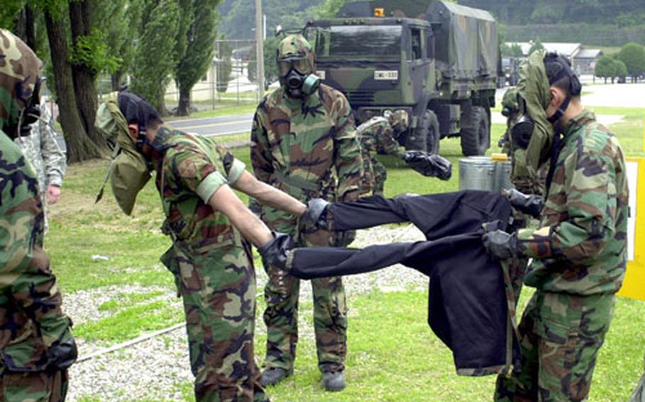 Clothing is removed from a soldier during the joint training exercise Tuesday at Camp Casey. U.S. and South Korean soldiers compared procedures in reacting to a simulated chemical attack.